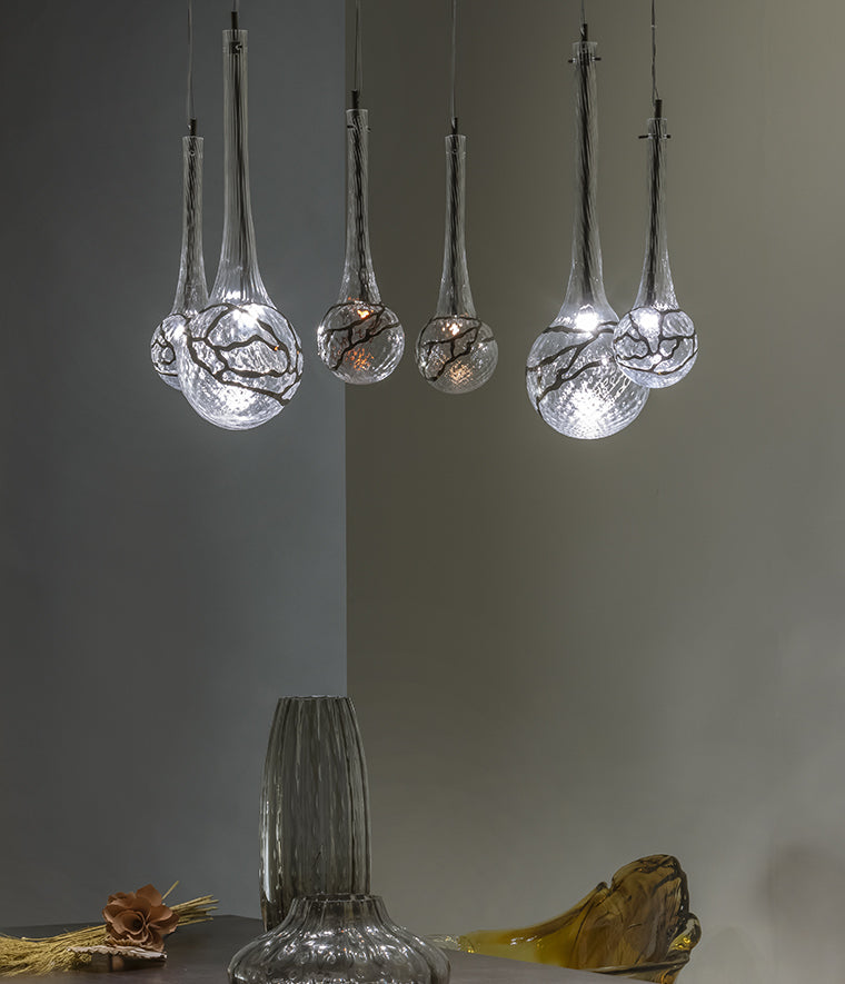 Lampada a sospensione modulabile su base ad arco in vetro soffiato e inserti metallici