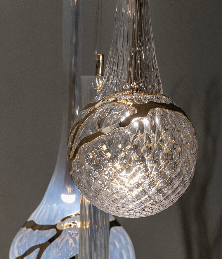 Lampada a sospensione modulabile su base ad arco in vetro soffiato e inserti metallici