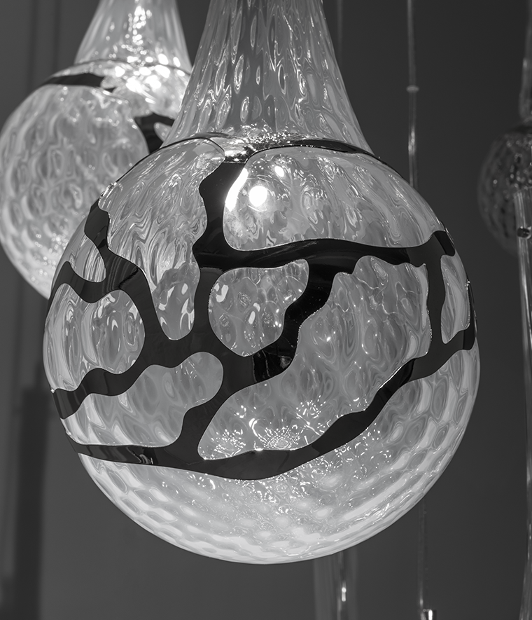 Lampada a sospensione modulabile su base ad arco in vetro soffiato e inserti metallici